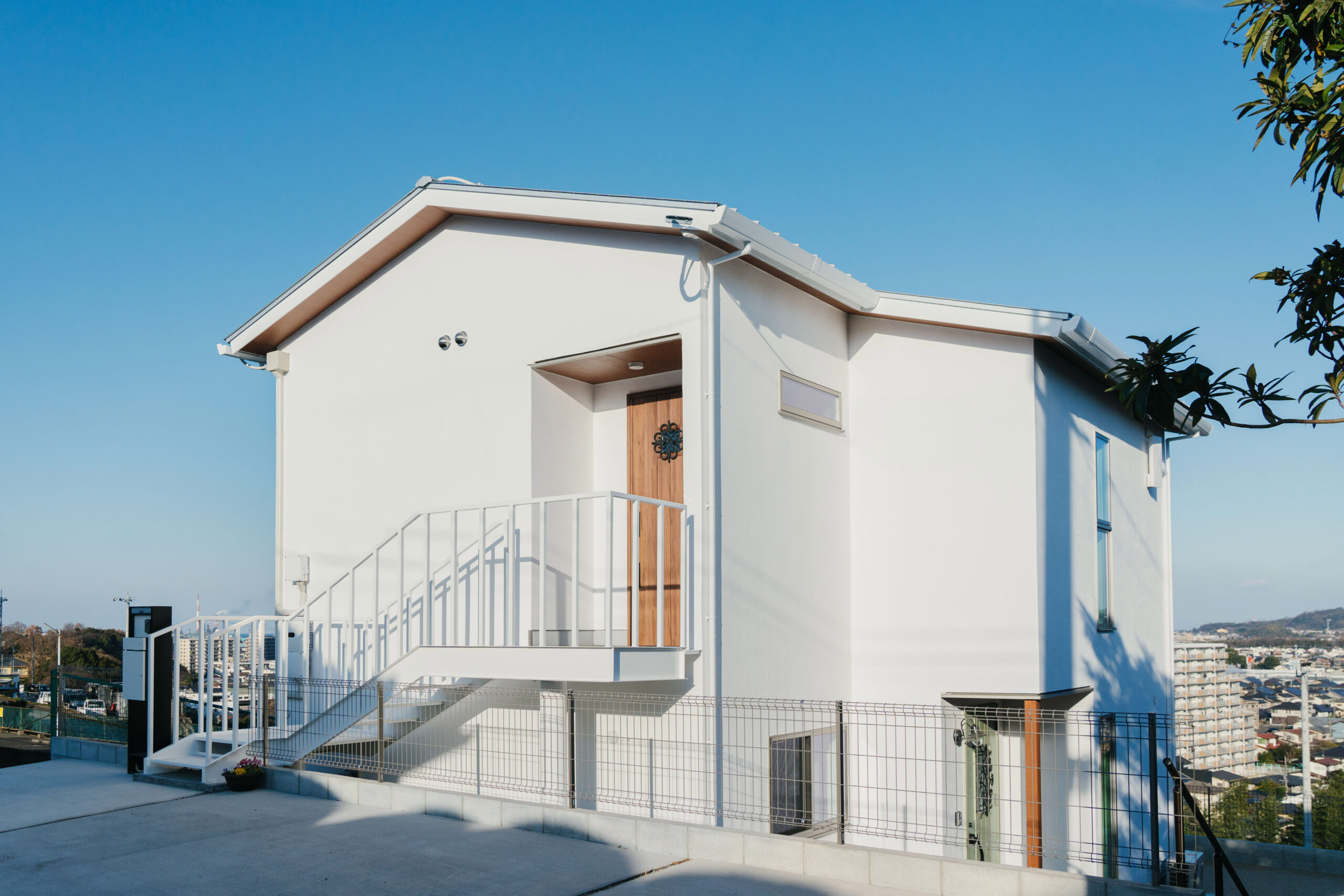 外壁までオール漆喰の住まい。1階と2階の 両方から出入りできるように、玄関は2つ。