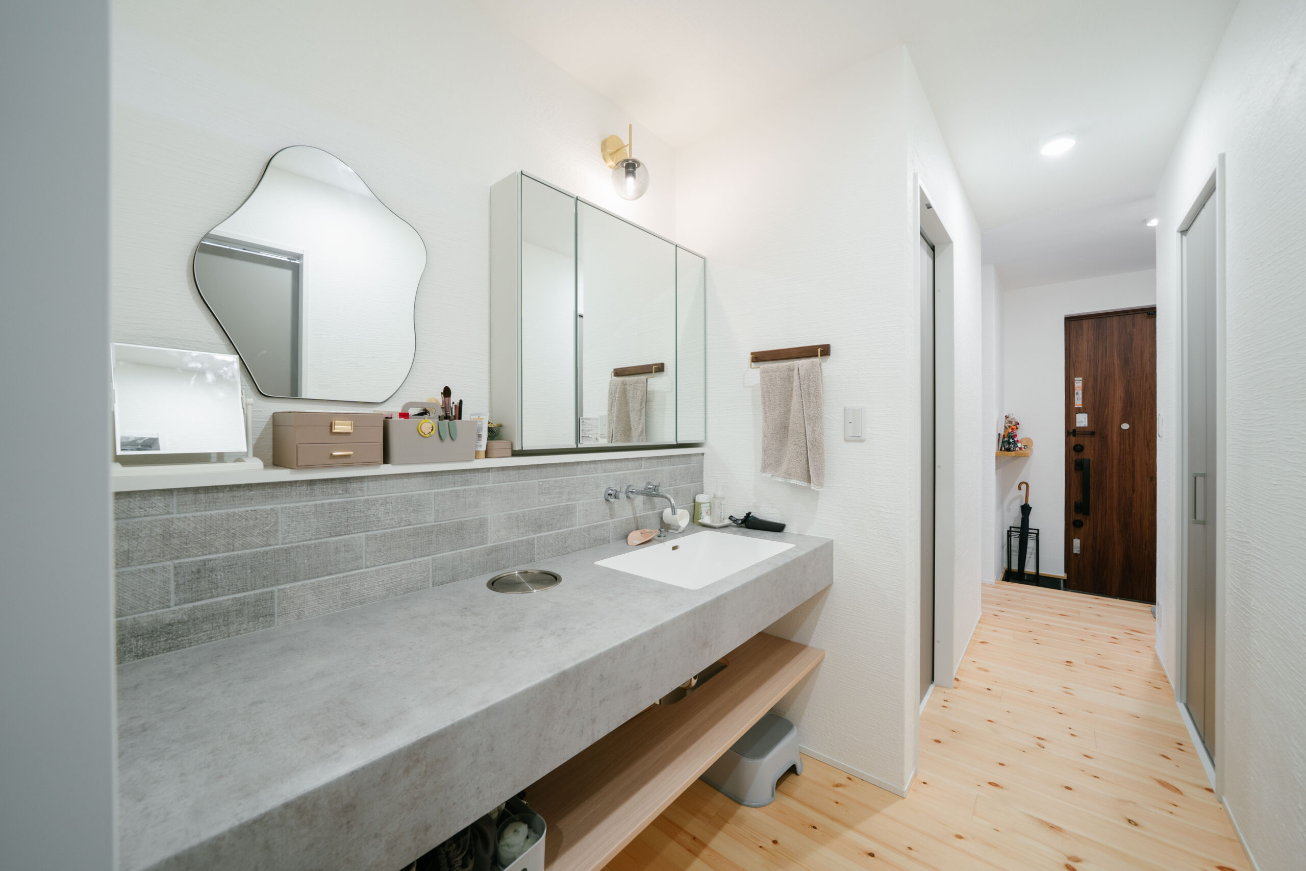 造作の洗面化粧台は独立空間に。スタイリッシュなカラーと素材感によって、ホテルライクな印象です。