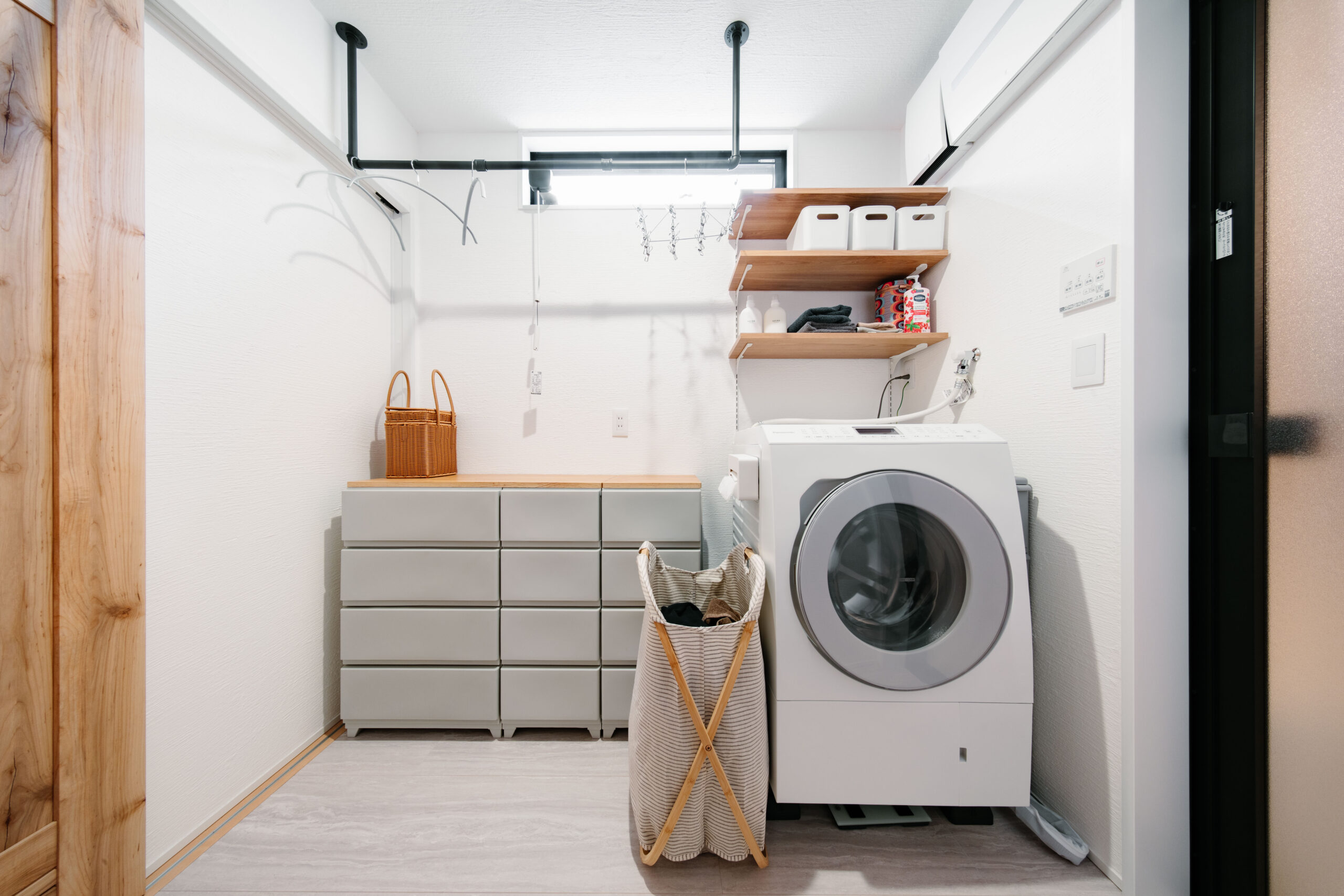 白を基調に木の棚やアイアンバーを組み合わせた、すっきりとした脱衣室。洗濯から室内干しまでスムーズに行える使いやすい空間です。
